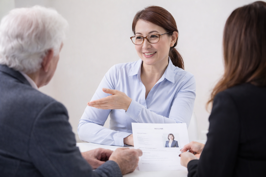 長年パソコン教室に通う受講生が笑顔でインタビューを受けている様子